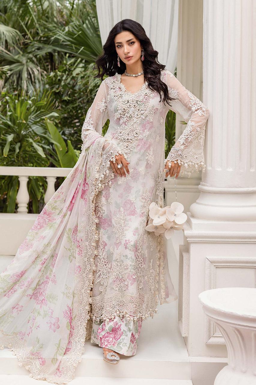 Woman in a floral and embroidered traditional outfit standing in an elegant outdoor setting.